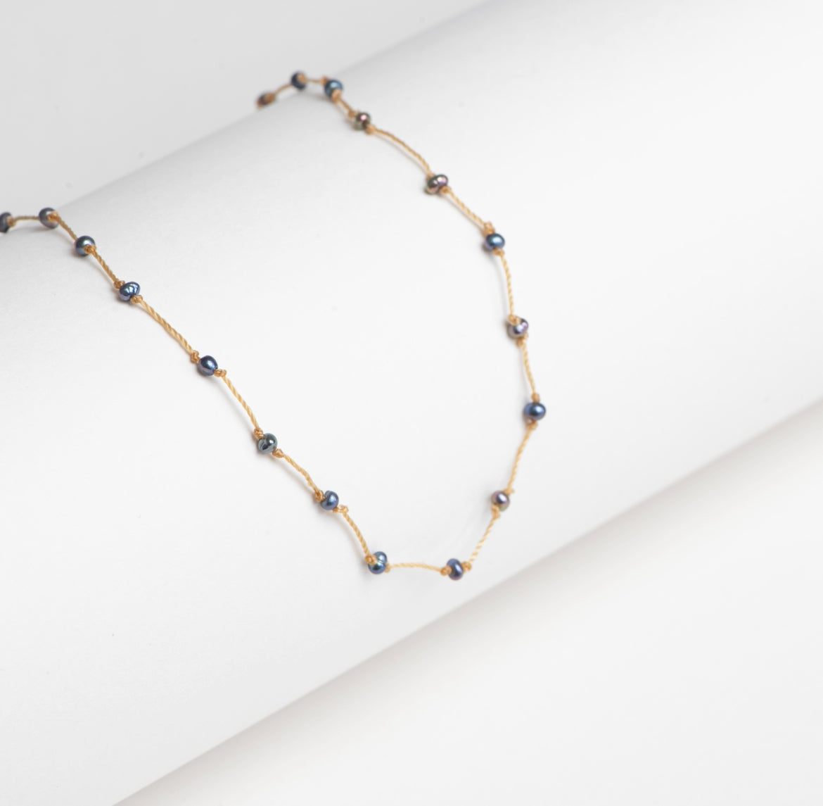 Collier perles mini noires irisées fil couleur beige