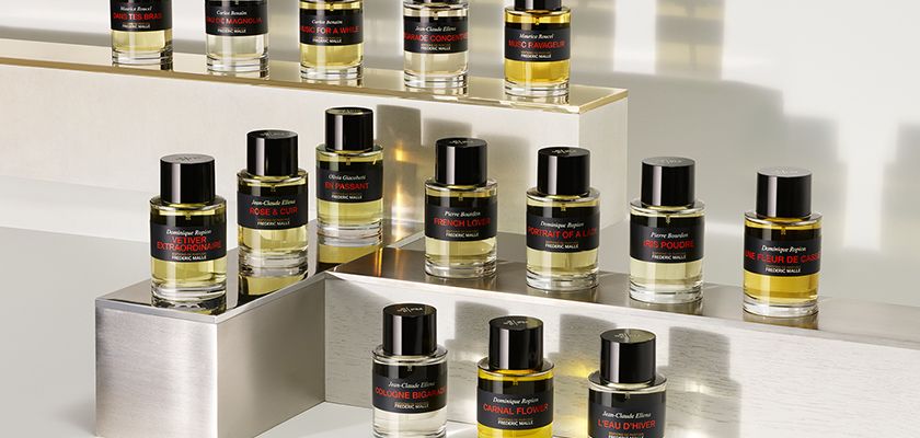 "Flacons rouges Frédéric Malle alignés sur une étagère élégante – Parfums d’auteur chez Maison Diaphane"