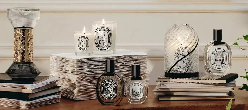 "Flacons et bougies Diptyque en lumière douce dans un décor raffiné, ambiance sensorielle chic."
