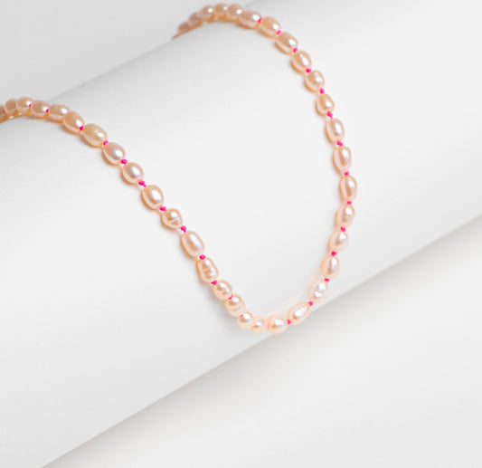 Collier plein perles olives rosées fil rose fluo